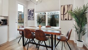 A dining area with a wooden table, four chairs, a vase, and a potted plant. - Warrenville Rep 2 (Warrenville)