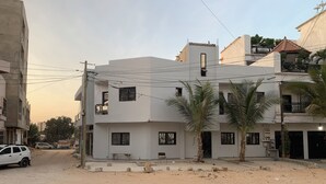 Un immeuble d’habitation à plusieurs étages, doté d’un toit plat, d’un balcon et d’une petite fenêtre.