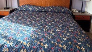 A hotel room with a large bed, two bedside tables, a headboard, and three framed pictures on the wall. - Federal way Motel (Federal Way)