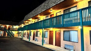 A motel with multiple rooms, a covered outdoor area, and a staircase leading to the upper floor. - Federal way Motel (Federal Way)