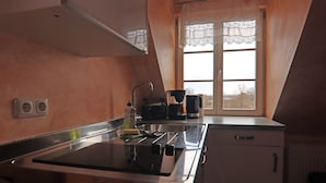 A kitchen with a stove, sink, and window. - Wunderschoene Ferienwohnung an der Mueritz (Röbel/Müritz)