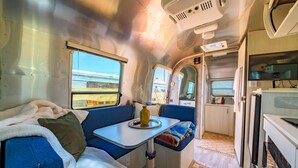 A cozy interior with a sofa, table, and kitchenette.