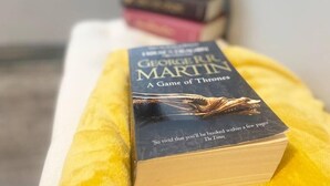 A book titled 'A Game of Thrones' by George R.R. Martin on a yellow pillow. - The Anchor - Open Plan Living in South Shields (South Shields)