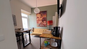 A compact living space with a kitchenette, a dining area, and a sofa. - Terrace bliss hot.Tub&city strolls ,5-10 m walk to restaurants and entertainment (Ponta Delgada)