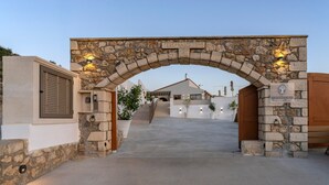 A stone archway with a plaque reading "FEVRENNAOZ 1943" and a sign for "Maximus Village."