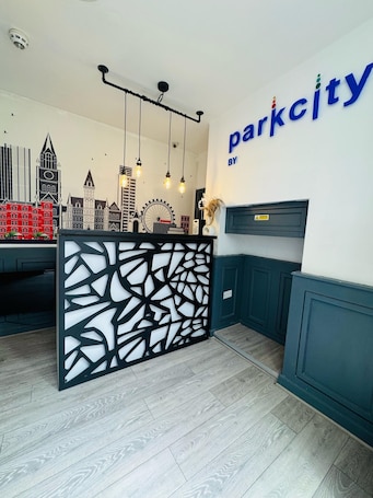 A reception area with a modern design, featuring a cityscape mural, a black and white decorative partition, and a sign that reads "parkcity by".