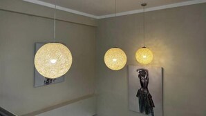 Un corridoio illuminato da tre lampade pendenti sferiche.
