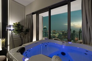 A modern bathroom with a large bathtub, a view of a cityscape, and a floor lamp. - Luxury2BR•Sea View•Hot Tub•Walk to Burj/Dubai Mall (Dubai)