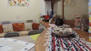 Un comedor con una mesa de madera, sillas y un protector de mesa tejido y colorido.