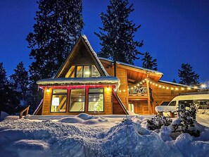 A wooden cabin with a large window, a covered porch, and a vehicle parked in front. - A-Frame w/Game Room, Close to Downtown, Mtn Views (Truckee)