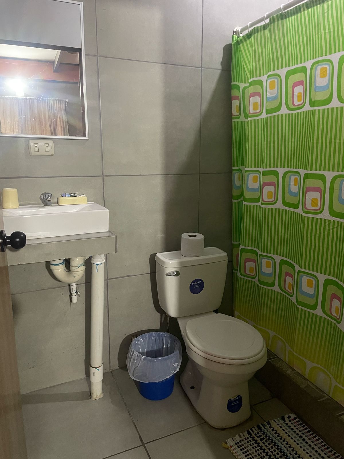 Ein Badezimmer mit Toilette, Waschbecken und Mülleimer.
