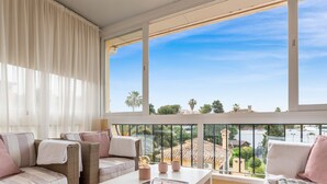 A balcony with wicker furniture, a view of the city, and a clear sky. - Santana | Sea views - garden - terrace (La Cala de Mijas)