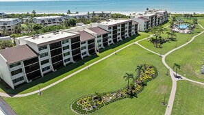 A hotel with multiple buildings, a well-maintained lawn, and a pool area.