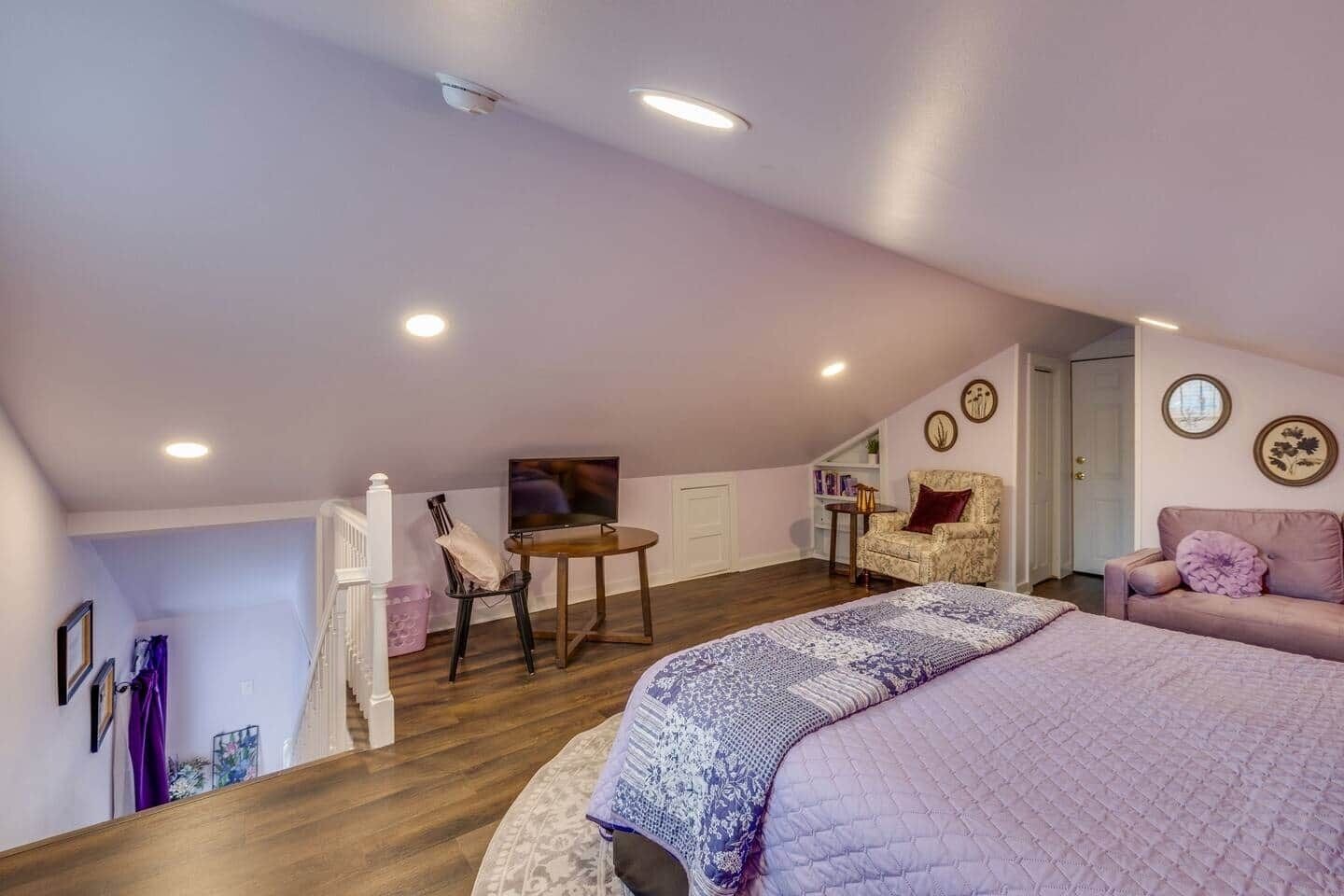 Un dormitorio con una cama grande, televisor, una silla y una mesita.