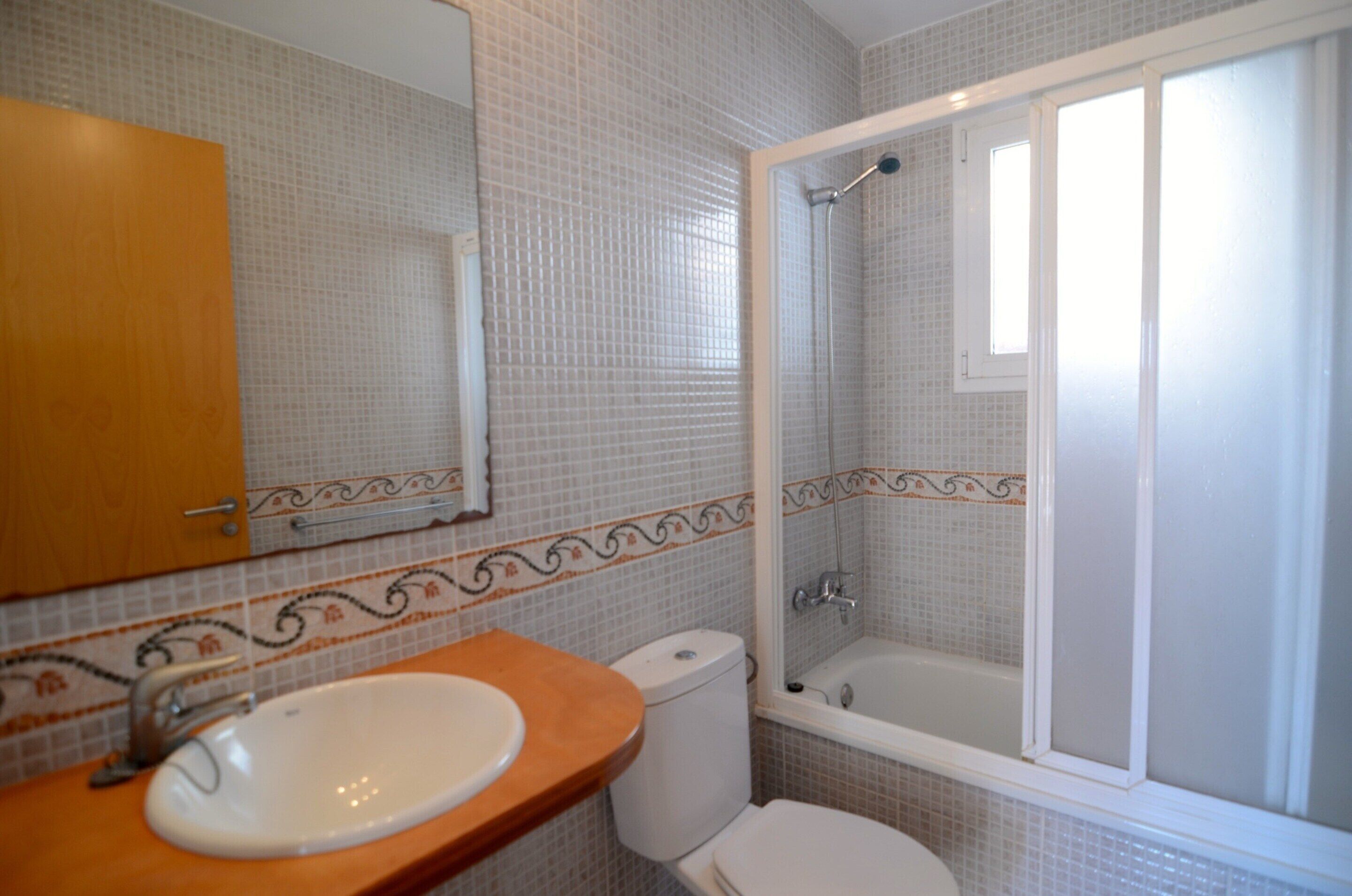 Une salle de bain avec un lavabo, des toilettes et une douche.