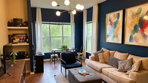 Ein modernes Wohnzimmer mit Sofa, Couchtisch und einem Essbereich mit Stühlen und Tisch.