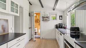 A kitchen with white cabinetry, a black countertop, and a stove.
