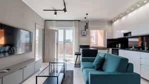 Un apartamento moderno con sala de estar, cocina y balcón.