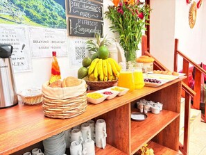 Un bufé de desayuno con una variedad de frutas, pasteles y bebidas.