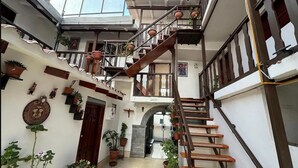 A multi-level interior with a staircase, potted plants, and a door labeled "SALIDA". - Hotel Horizonte Cuzco (Cusco)