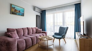 Un salon moderne avec un canapé, un fauteuil et une petite table ronde agrémentée de sets de table en fibres tressées.