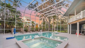 A pool area with a swan decoration, lounge chairs, and a glass-enclosed structure. - Salty Sailfish | Private Pool + Hot Tub + Siesta Key (Sarasota)