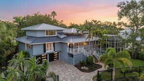 A two-story house with a balcony, a staircase, and a pool. - Salty Sailfish | Private Pool + Hot Tub + Siesta Key (Sarasota)