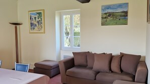 A living room with a sofa, a table, and a window. - Heritage Hideaway With Garden & Charm (Thorée-les-Pins)