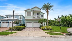 A two-story house with a front garage, a driveway, and a palm tree. - Embrace Luxury: Your Perfect Escape, Orlando Villa 1000 (Kissimmee)