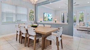 A dining area with a wooden table and chairs, a chandelier, and artwork on the walls. - Embrace Luxury: Your Perfect Escape, Orlando Villa 1000 (Kissimmee)