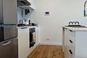 Una cocina compacta con horno empotrado, cocina y una pequeña encimera.