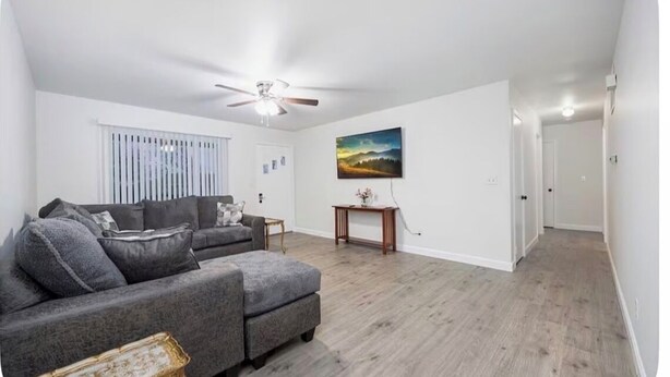 A living room with a grey sofa, a small table, a ceiling fan, and a painting on the wall. - 3-bedroom house in delightful Dayton with WiFi, AC (Dayton)