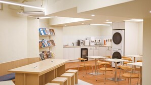 A modern kitchen with white cabinets, a washing machine, and a coffee machine. - Bluenote (Incheon)