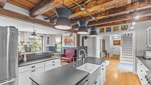 A modern kitchen with a large island, stainless steel appliances, and pendant lighting.
