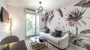 A modern living room with a sofa, coffee table, and a large window. - L'OISEAU PARADIS - Studio Gare de Vaise (Lyon)
