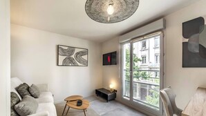 A modern living room with a sofa, a coffee table, and artwork on the walls. - LA PALMERAIE - Studio Valmy Metro Station (Lyon)