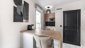 A modern kitchen with a wooden countertop, a coffee machine, and a microwave. There is a door and a window with a view of the outside. - LA PALMERAIE - Studio Valmy Metro Station (Lyon)