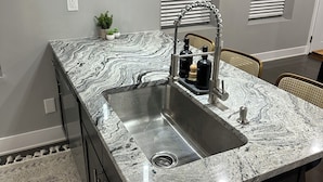 A kitchen with a granite countertop, stainless steel sink, and modern fixtures. - Newly renovated! 2b-2b dbl in Gordon Square, Cleveland! 5mins from downtown! (Cleveland)