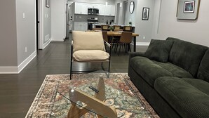 A modern living room with a sofa, a coffee table, and a dining area with chairs and a table. - Newly renovated! 2b-2b dbl in Gordon Square, Cleveland! 5mins from downtown! (Cleveland)