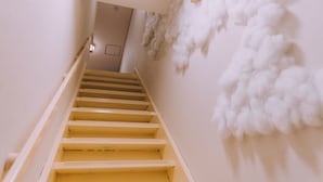 A staircase with a handrail and a wall with a textured white pattern. - Shinsaibashi Cloud House | Sauna | Sleeps 8 (Osaka)