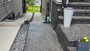 A residential driveway with a gravel pathway leading to a house with stone and siding exterior. - Charming 1-bedroom walkout pond backing suite with fitness machine, AC and bbq (Beaumont)