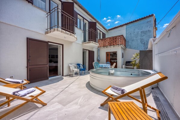 Una propiedad residencial con piscina, mobiliario exterior y balcón.
