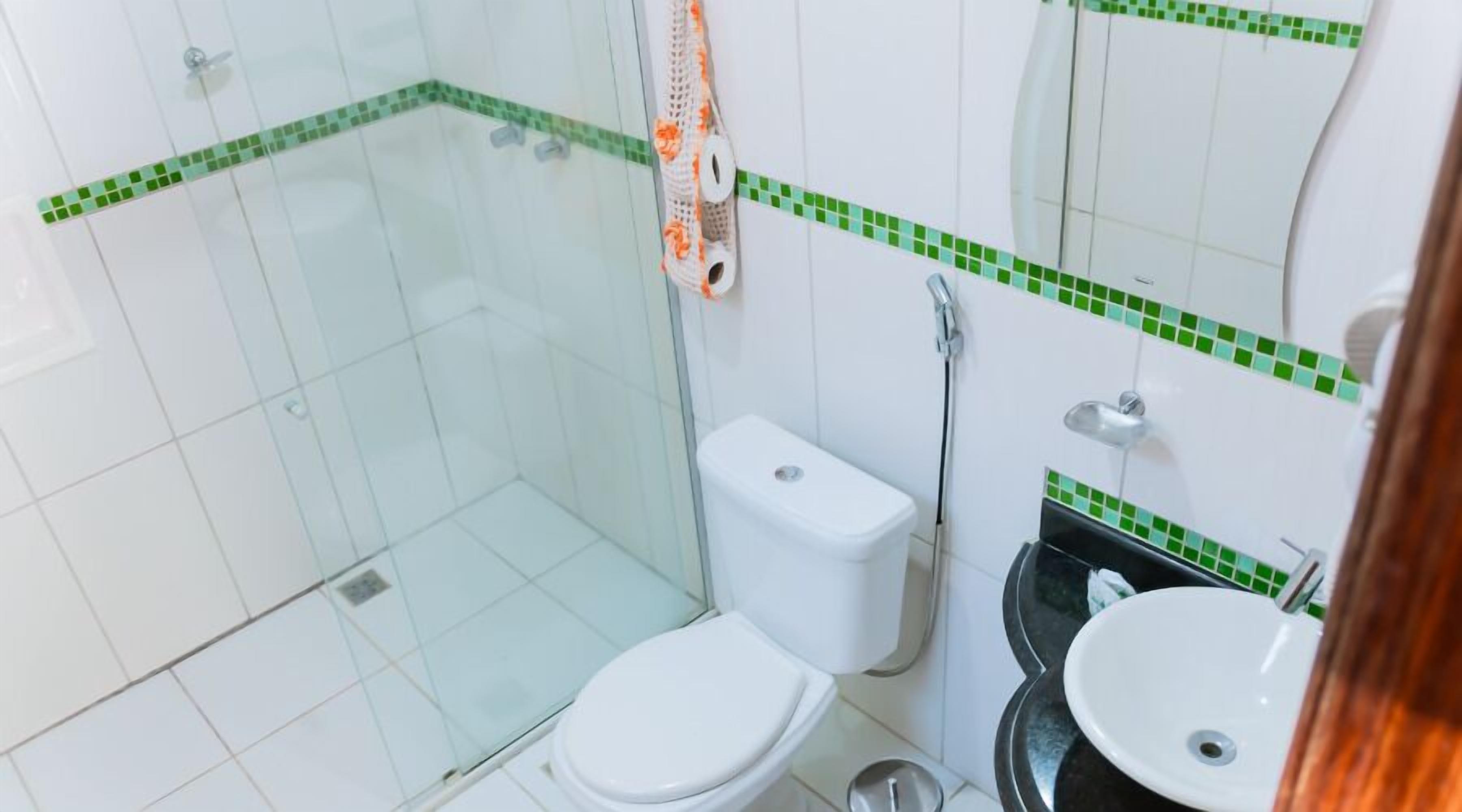 A bathroom with a toilet, sink, and shower area.