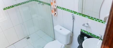 A bathroom with a toilet, sink, and shower area.