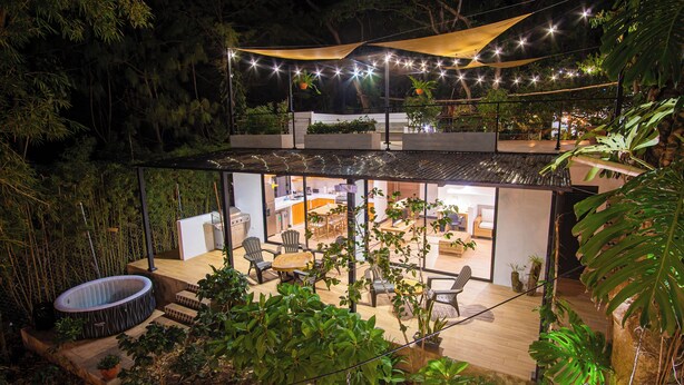 A modern house with a glass-enclosed living area, a hot tub, and a dining space. - House of the Baobas! "Your home in the nature of Atitlán". (San Juan La Laguna)