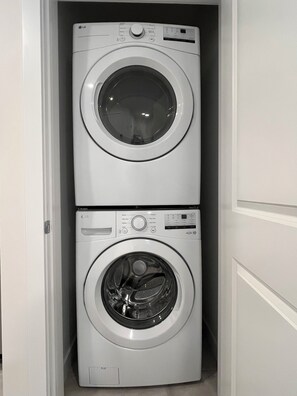 A compact laundry room with two stacked washing machines.
