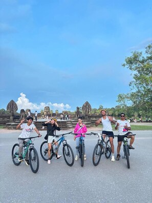 Un groupe de personnes à vélo devant d’anciennes constructions en pierre.