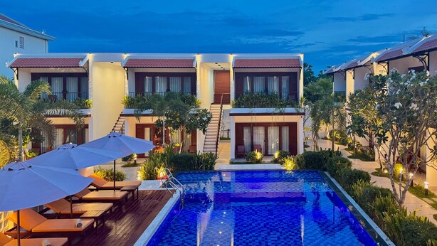 A modern hotel with a swimming pool, outdoor seating, and a well-maintained garden. - Happy Resort Siem Reap (Siem Reap)