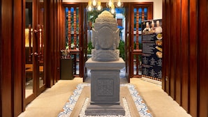 A hallway with a central statue, wooden doors, and a chandelier. - Happy Resort Siem Reap (Siem Reap)