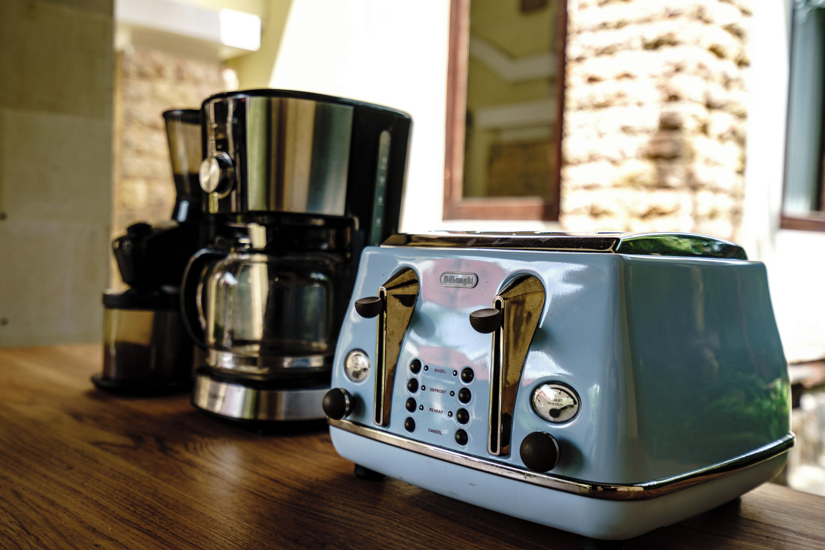 A vintage toaster and a coffee maker on a wooden table.